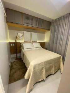 a bedroom with a large bed with white sheets and pillows at Apartamento Sunset Residence in Dourados +28 photos