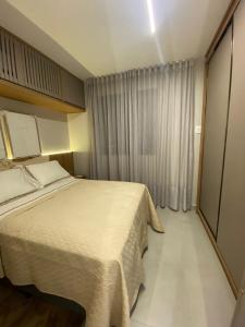 a hotel room with a bed and a window at Apartamento Sunset Residence in Dourados