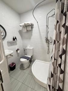 a bathroom with a toilet and a sink and a shower at PJ Hostel & Bar in Pattaya
