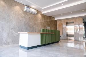 a lobby with a green and white counter and a wall at Luxury Studios by Home in Mpehuasem +23 photos
