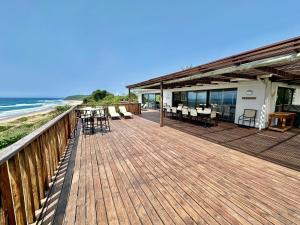 a wooden deck with chairs and tables on the beach at Kangela 1 in Ponta Malongane