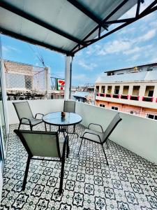 a patio with chairs and a table on a balcony at PJ Hostel & Bar in Pattaya +20 photos