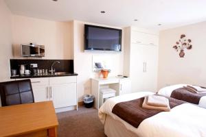 a bedroom with two beds and a kitchen with a sink at The White Hart in Caistor
