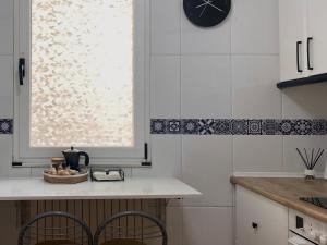 a kitchen with a counter with two chairs and a clock at Príncipe León by ARoom VUT-LE- 768 in León