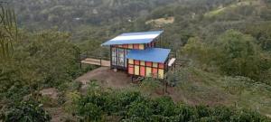 a small house with a blue roof on a hill at Cabaña Alegria in San Francisco