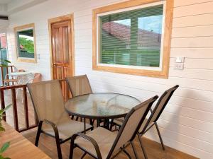 a table and chairs on a porch with a window at The O room in Ko Larn