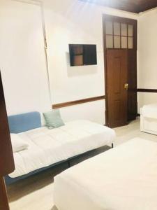 a living room with a couch and a tv at Private Room 102 in Guest house da Fonte in Figueira da Foz +11 photos