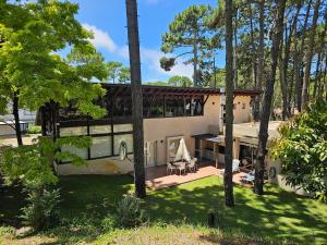 a house in the woods with a patio and trees at Casa SHANTI in Pinamar