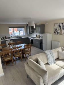 a living room and kitchen with a couch and a table at Newark area - modern 3 bedroom semi with free off road parking for 2 vehicles in Balderton