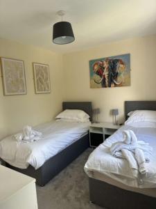 a bedroom with two beds with towels on them at Newark area - modern 3 bedroom semi with free off road parking for 2 vehicles in Balderton +2 photos