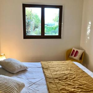 a bedroom with a bed and a window at La Causeuse in Thonon-les-Bains