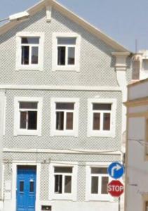 a large white house with blue doors and a stop sign at Private Room 201 in Guest House da Fonte in Figueira da Foz +8 photos