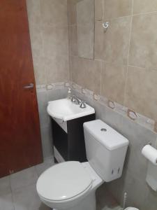 een badkamer met een wit toilet en een wastafel bij El Atardecer in Oro Grueso