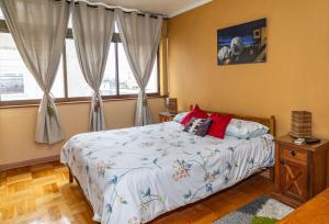 a bedroom with a bed and two windows at Departamento Freire in Valparaíso +27 photos
