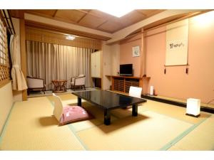 a living room with a table and a chair at Inatori Tokai Hotel Yuen - Vacation STAY 31868v in Inatori +36 photos