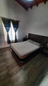 un dormitorio con una cama en una habitación en Monchos House, en Merlo 7 fotos más