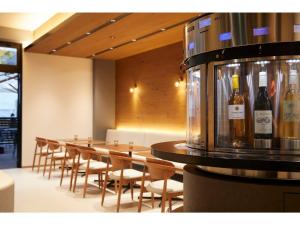 大阪市にあるＨＯＴＥＬ ＳＡＩＬＳ - Vacation STAY 37326vのワインのボトルと一列のテーブルと椅子