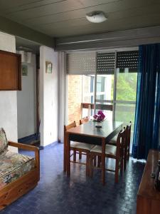 a dining room with a table and chairs and a bed at Departamentos frente al mar-Villa Gesell in Villa Gesell