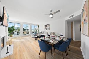 een eetkamer en woonkamer met een tafel en stoelen bij The Turquoise Lounge - Chic 2BR Beach view Pool, Sauna in Los Angeles