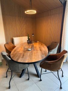 a wooden table in a room with chairs around it at De Paer - Hof van Libeek in Sint Geertruid +4 photos