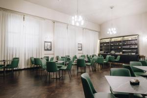 a dining room with green chairs and tables at Hotel Impero in Cremona +37 photos
