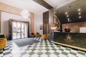 a lobby of a hotel with a counter and a bar at Hotel Impero in Cremona