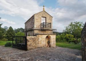 an old stone church with a cross on top at Casa Horreo lar san Adrián in A Coruña