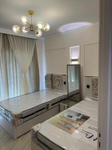 Cette chambre comprend deux lits et un lustre. dans l'établissement القاهرة الجديدة مدينتي, à Madinaty