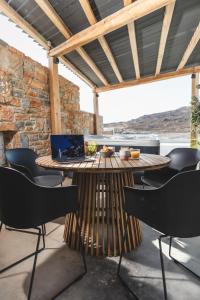 a patio with a table with a laptop on it at Harmony Luxury Villas Naxos in Kastraki Naxou
