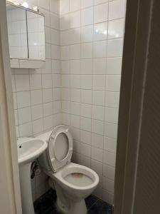 a small bathroom with a toilet and a sink at Appartement en centre-ville in Roissy-en-France