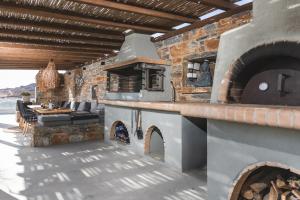 an outdoor patio with an outdoor pizza oven at Harmony Luxury Villa Naxos in Kastraki Naxou