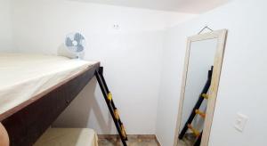 a bed with a fan next to a mirror at Three A Diárias in Mata de Sao Joao +2 photos