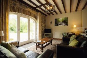 a living room with a couch and a table at Coach House Cottage at Scolton - Indoor pool in HAW