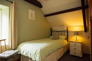 a bedroom with a bed and a lamp on a night stand at Coach House Cottage at Scolton - Indoor pool in HAW +20 photos