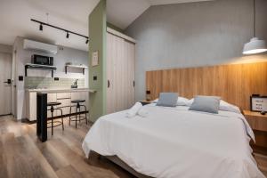 メデジンにあるCasa Origo Hospedajeのベッドルーム(大きな白いベッド1台付)、キッチンが備わります。