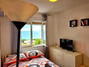 a bedroom with a bed and a large window at Studio apartman Mateo in Rijeka