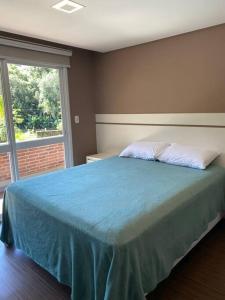 een slaapkamer met een blauw bed en een raam bij Sitio Entre Rios in Guaporé +10 foto's