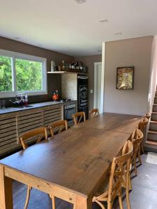 een grote houten tafel in een keuken met stoelen bij Sitio Entre Rios in Guaporé