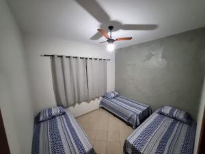 2 camas num quarto com uma ventoinha de tecto em Apartamento Vip no Frade em Angra dos Reis