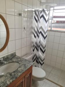 um banheiro com uma pia, um vaso sanitário e um espelho em Apartamento Vip no Frade em Angra dos Reis