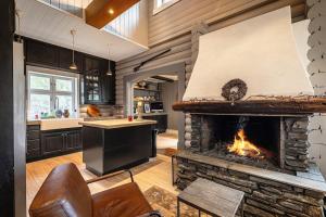 a living room with a fireplace in a kitchen at Hemsedal Mountain Retreat in Hemsedal