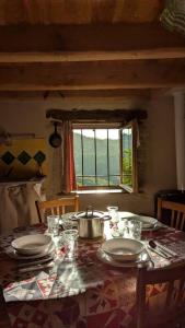 a table with plates and a pot and a window at Entire Gite in Espeyrac 'Le Clapadou' in Espeyrac +13 photos
