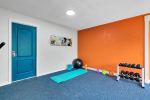 a room with a gym with a door and weights at Oasis 105 - Blue Bliss in Titusville