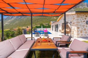 a patio with a couch and a table on a deck at Villa estrella in Kaş