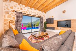 a living room with a couch and a tv at Villa estrella in Kaş