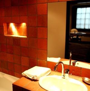 a bathroom with a sink and a mirror and a tub at Les Demoiselles de Ladoix in Ladoix Serrigny