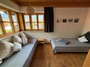 - un salon avec un canapé et des fenêtres dans l'établissement Bett & Berge - Ferienwohnung in den Schlierseer Bergen, à Schliersee