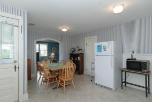 a kitchen with a table and a white refrigerator at Craft Upper Unit by Bryant Real Estate in Wrightsville Beach +18 photos