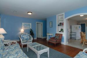 a living room with blue walls and a table and chairs at Craft Upper Unit by Bryant Real Estate in Wrightsville Beach