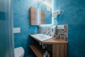 une salle de bain avec un lavabo et un miroir dans l'établissement Monolocale La casa delle fate, à Madonna di Campiglio 6 autres photos